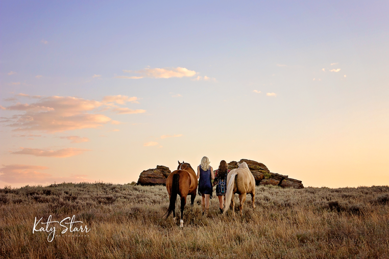 western lifestyle photo session two sisters walking away with horses